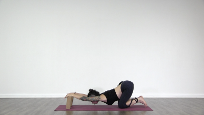 Lizette is practising yoga on a green yoga mat