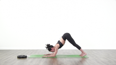Yoga teacher performing yoga posture on green yoga mat on white background